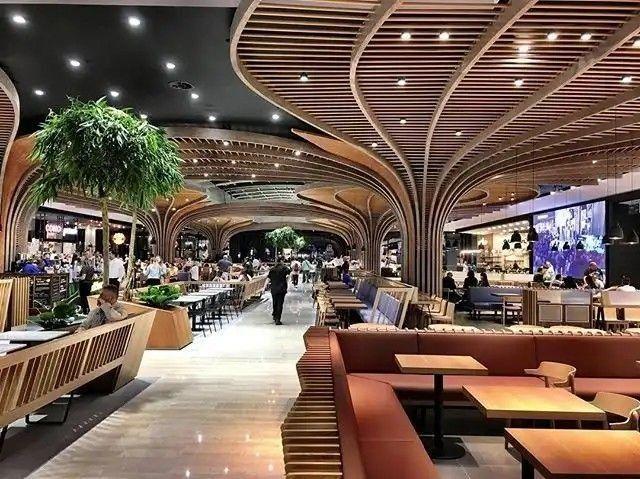 طراحی داخلی فودکورت مدرن با مبلمان چوبی، میز و صندلی رستورانی لوکس و سقف منحنی چوبی – پروژه اجرا شده توسط هنر صنعت اوان