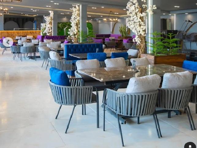 چیدمان لوکس میز رستورانی سنگی با صندلی کنفی راحتی و نشیمن ابری، مناسب فضاهای کافی‌شاپ، رستوران و سالن تشریفاتی – طراحی مدرن با رنگ‌های طوسی و آبی